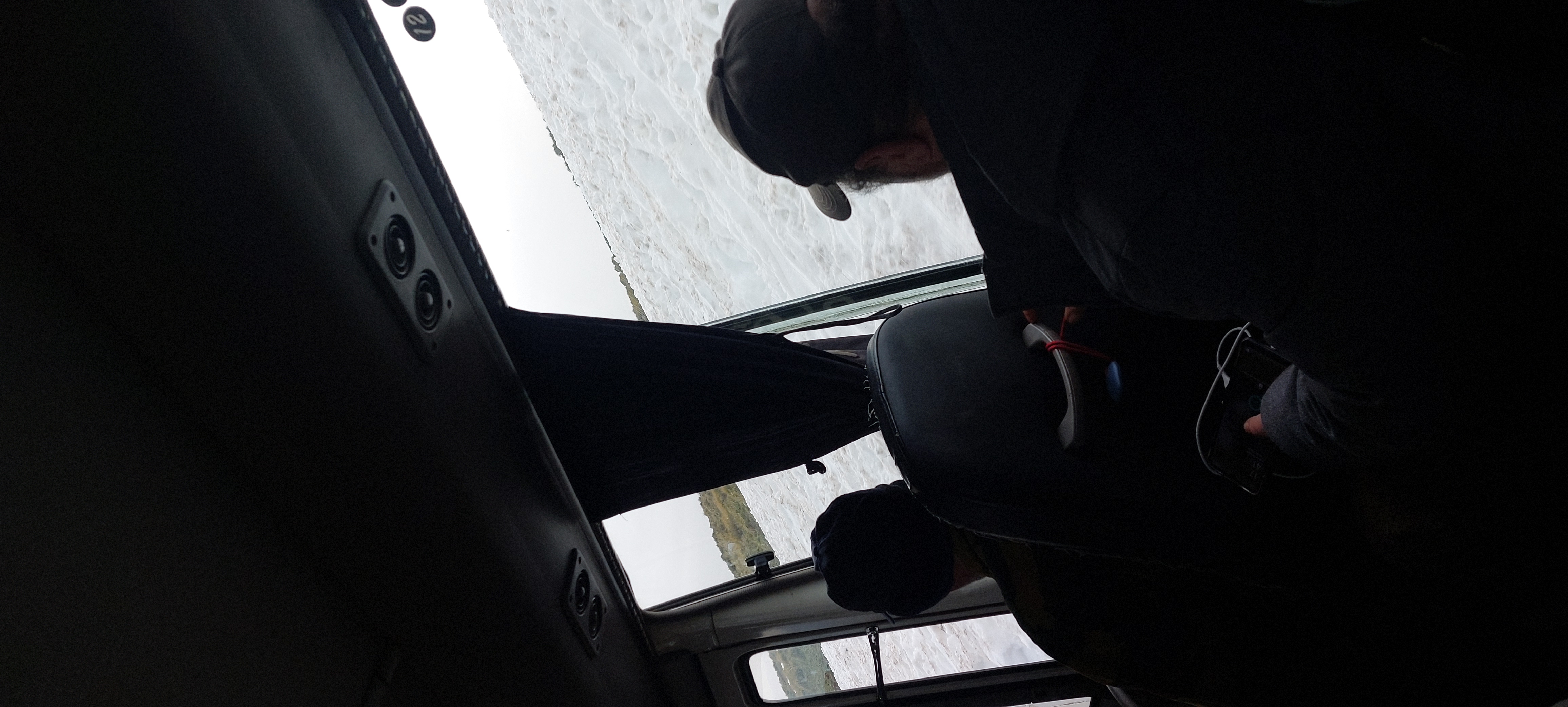 Des voyageurs regardent un paysage enneigé depuis un autocar.